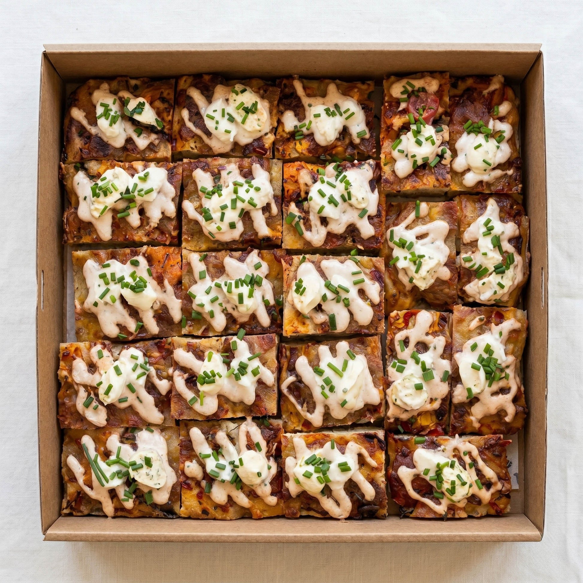 Focaccia Pizza Box (10pc) from Double Dribble — golden focaccia pizza squares with melted cheese, aioli and chives, cut into shareable pieces in a kraft catering box