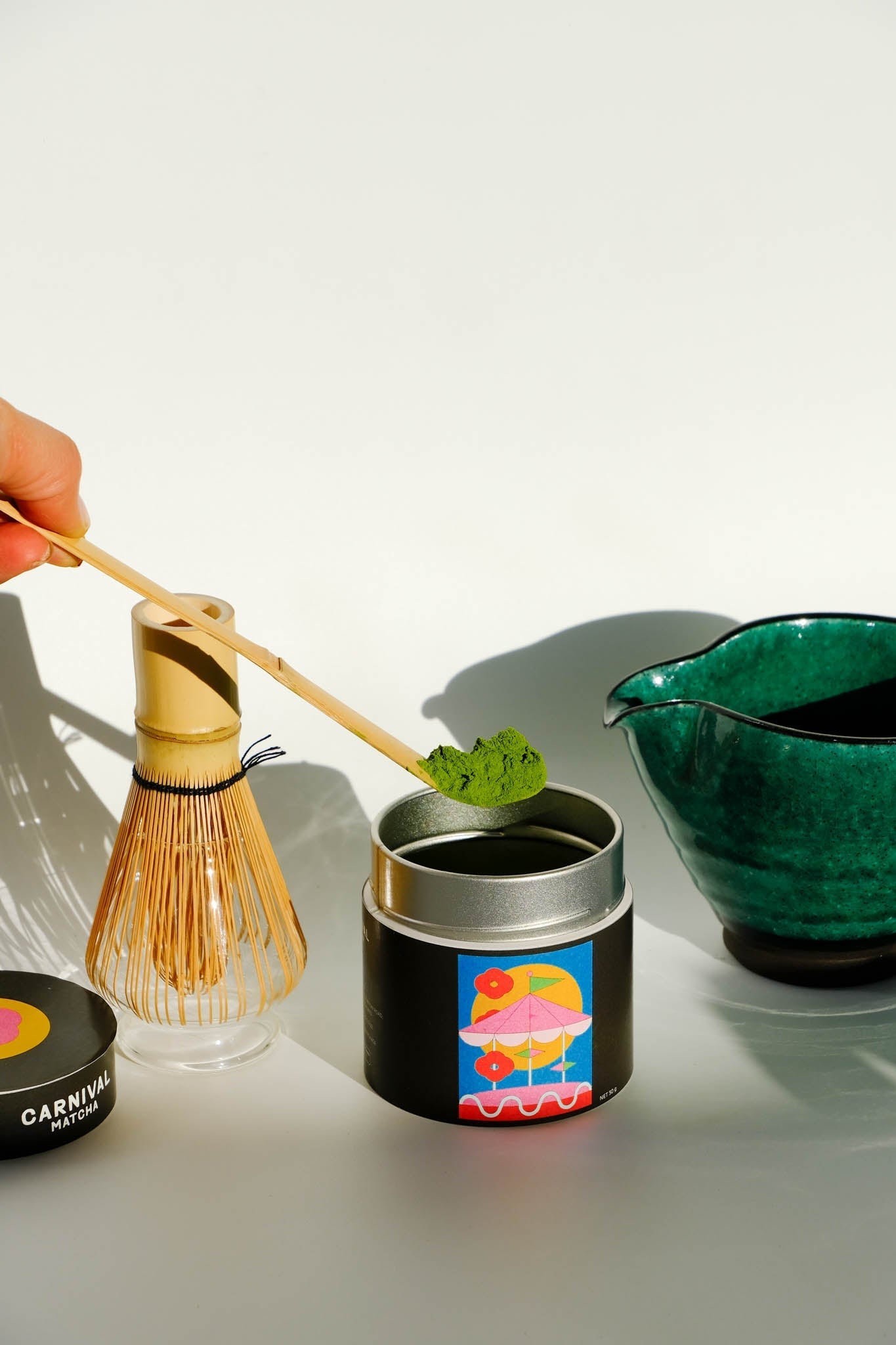 Carnival Matcha Iroiro 30g tin being scooped with a bamboo chasen