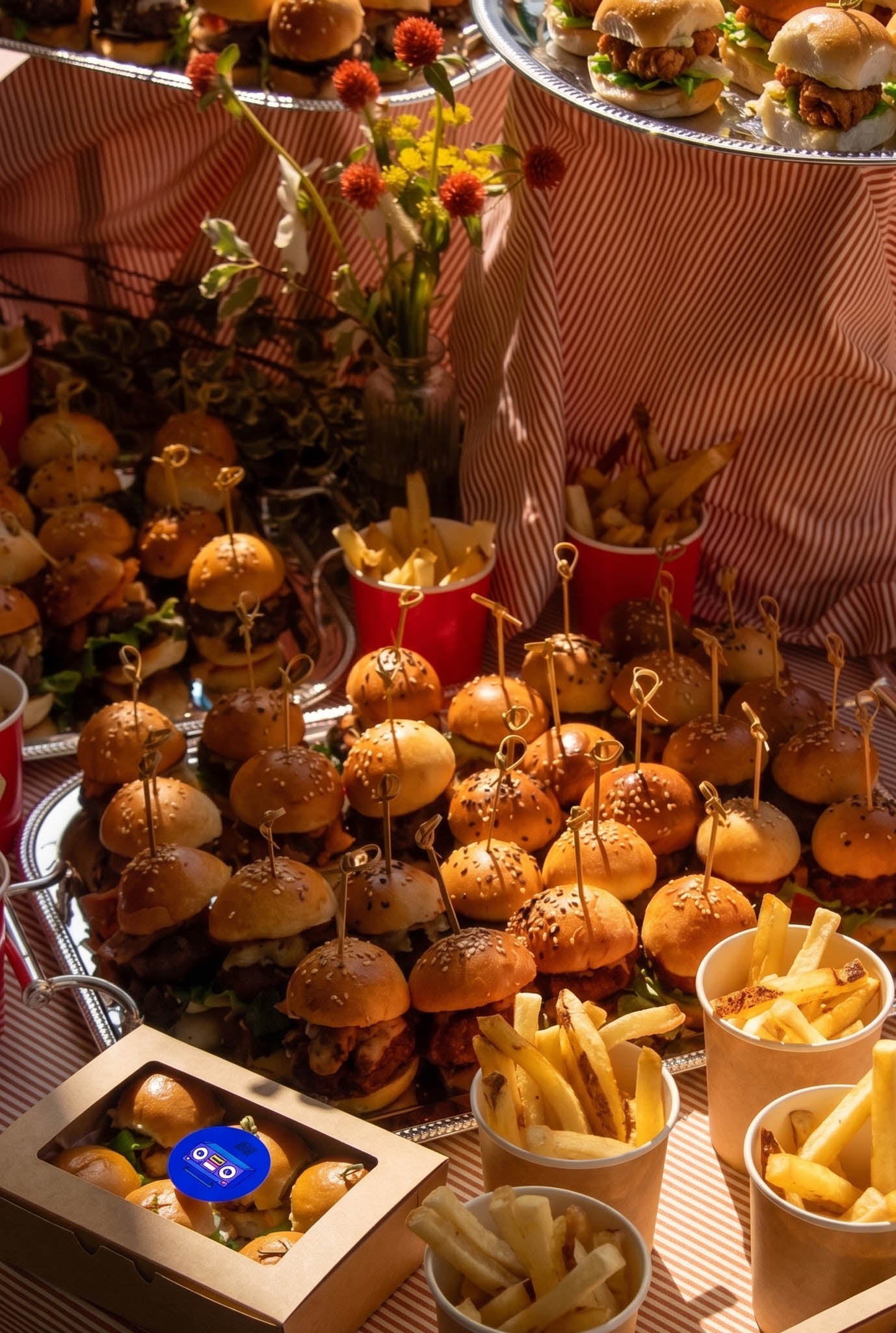Double Dribble mini chicken burger sliders styled on tiered catering platters with cups of fries — party and event catering