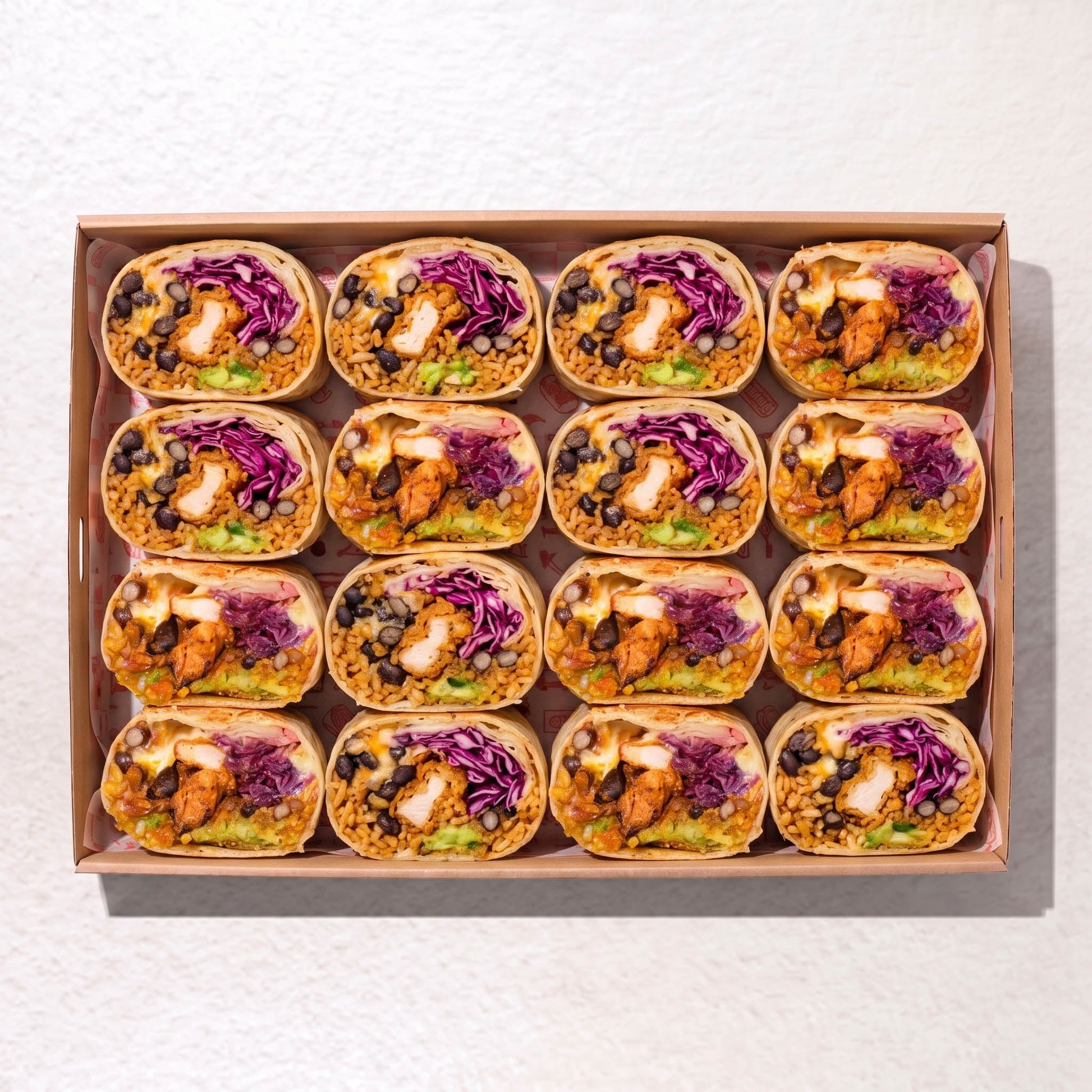Muy Muy burrito box from Double Dribble Catering Christchurch — soft-wrapped burritos with guacamole, cheese, black beans, salad and grilled chicken, arranged in a catering tray.