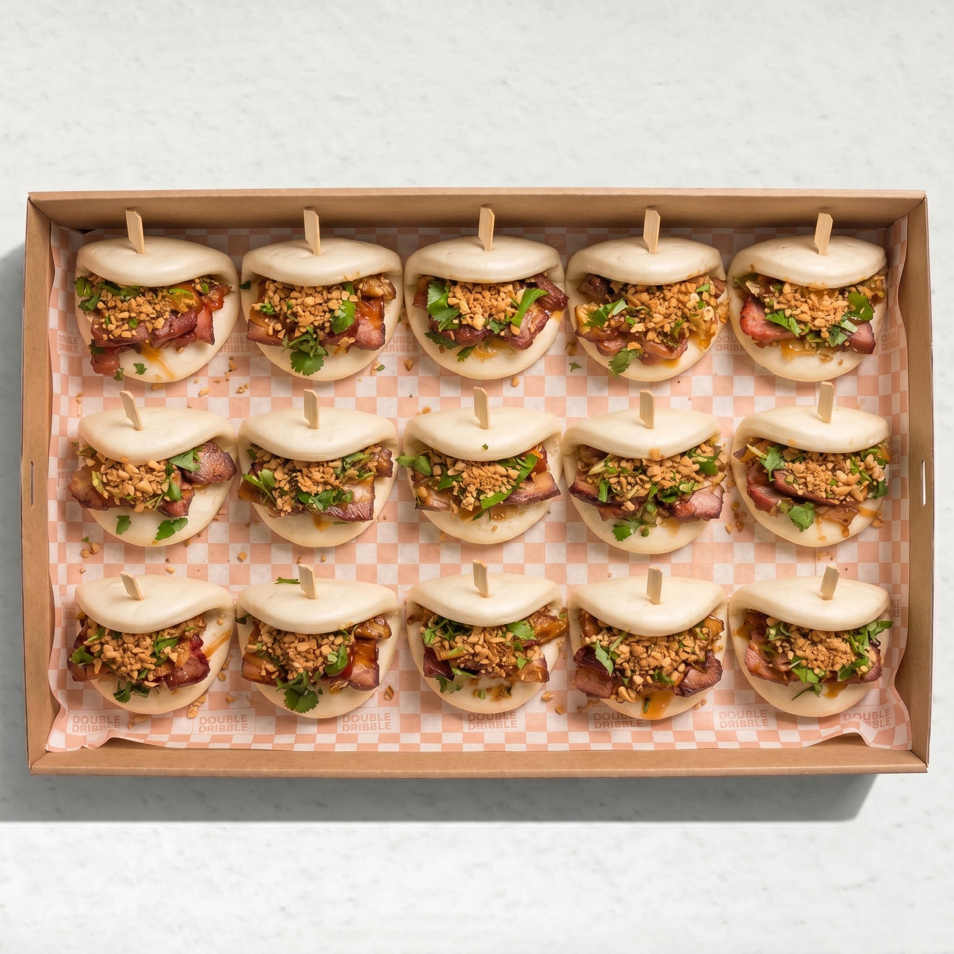 Pork Belly Bao Platter (20pc) from Double Dribble — soft steamed bao buns with pork belly topped with crushed peanut and coriander in a kraft catering box